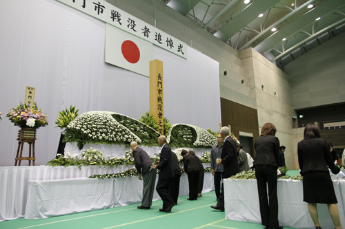 参列者は順に祭壇の前に立ち、献花を行う