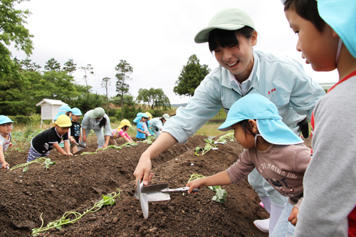 生徒から手順を教わりながら、苗植えを楽しむ