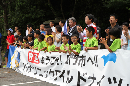 横断幕を掲げ、拍手で出迎える