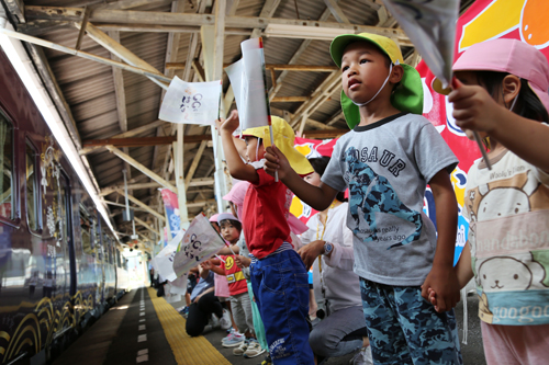 この日、長門市駅では、深川幼稚園の園児が手旗を振って列車を出迎えた