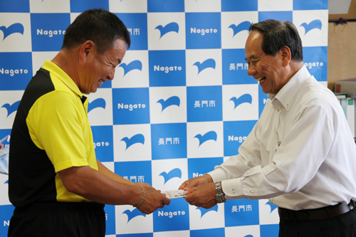 大西市長から激励費とTシャツが手渡される