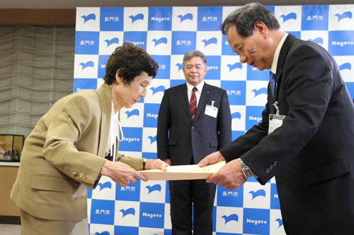 妻の久子さんに勲記と勲章が手渡される