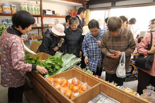 新鮮な野菜類などを買い求める住民ら