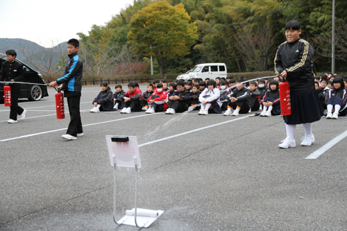 三隅中学校の生徒は、練習用の水消火器を使った初期消火訓練に挑戦