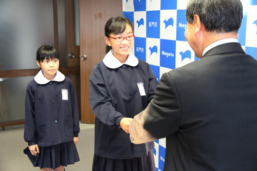 大西市長から激励費とTシャツが手渡される