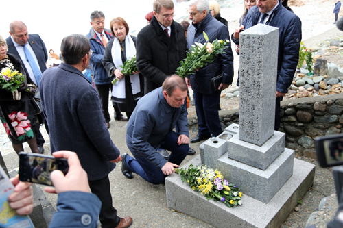 通地区の大越の浜にある日露兵士の墓碑に花を供えるパホモフ市長