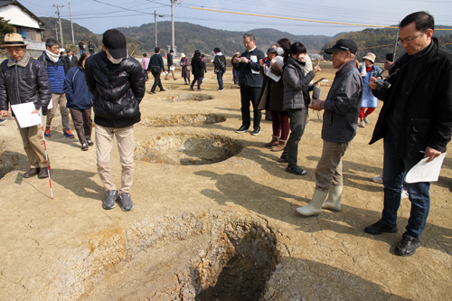 遺構跡を興味深そうにのぞき込む参加者ら