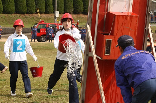 的に向かって勢いよく水をかける水バケツ消火競技