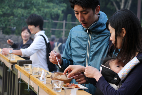 橋の上でやきとりなどの鶏料理やドリンクを楽しむ