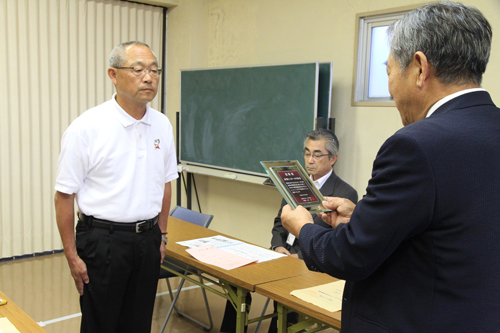 盾を手渡される長門陸上スポーツ少年団の百合野康也代表