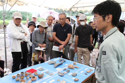 本郷遺跡の出土品を興味深く見つめる参加者たち