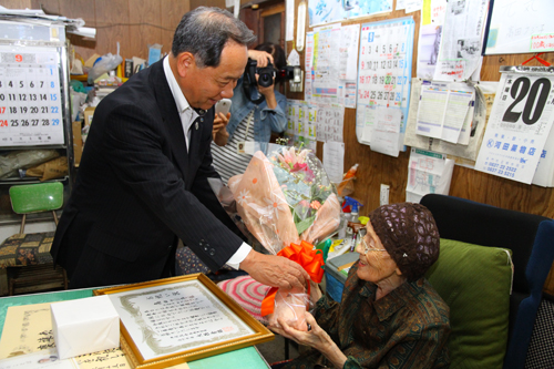 花束が手渡され笑みを浮かべる高田さん