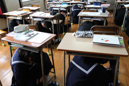安全姿勢をとり、頭を守る