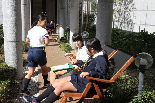 中庭でくつろぐ児童ら