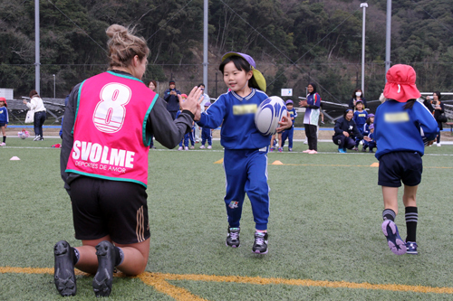 ボールを持って選手とハイタッチ