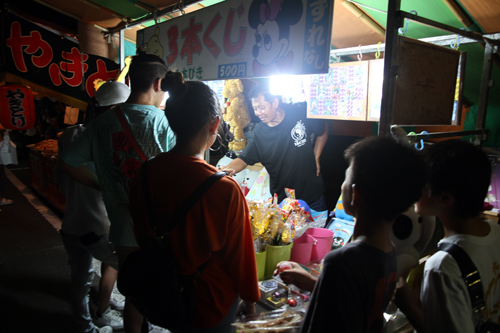 花火が始まるまでの間、露店での買い物を楽しむ