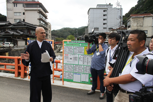 恩湯の建設現場で概要を説明する大谷代表