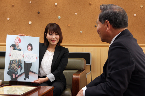 大会で披露したモデルの髪形を写真パネルで紹介する保多盛さん