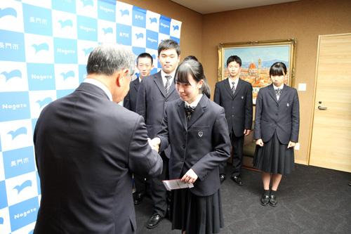 久保田さんが代表して大西市長から激励費を受け取る