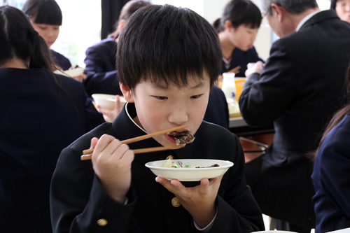 児童らはおいしそうにくじら肉をほおばる