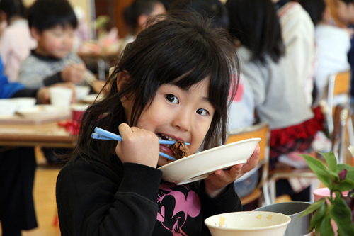 クジラの竜田揚げを美味しそうにほおばる