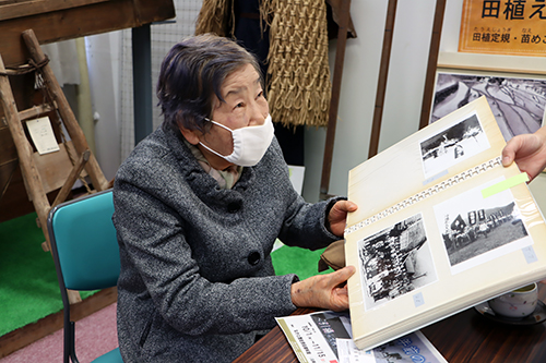 当時の写真を見て懐かしむ渡辺さん