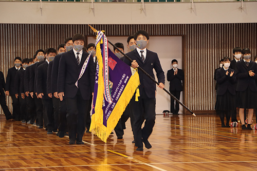 県大会の優勝旗を持つ林主将を先頭に入場する選手