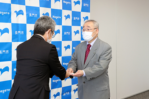 光永市民福祉部長から竹内さんに報奨金が贈呈された