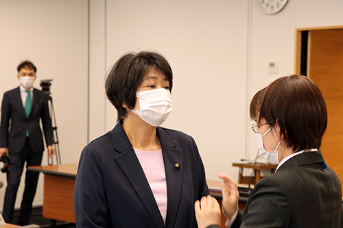議会事務局書記が議員一人ひとりに議員章を交付
