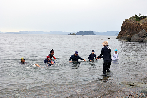 いちばん短いチャレンジコースに挑戦した児童を地域の人が海に入って応援