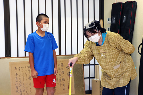 西地域包括支援センター職員が認知症のお年寄りに扮し、子どもたちが声のかけ方を実践で学んだ
