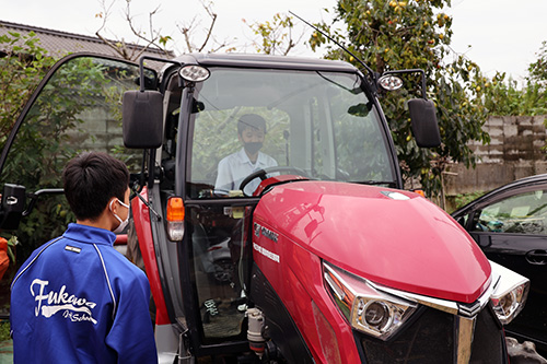 トラクターの運転席に座る生徒。エアコンなどの設備が整っている