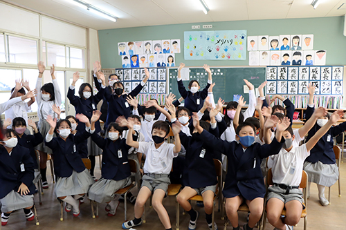 他校の児童に手を振る仙崎小学校の児童