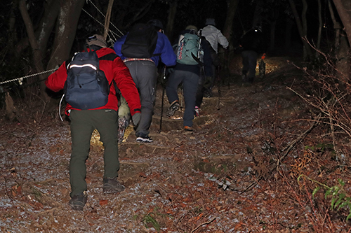 夜明け前の暗闇の中、ライトをたよりにゆっくりと山を登る