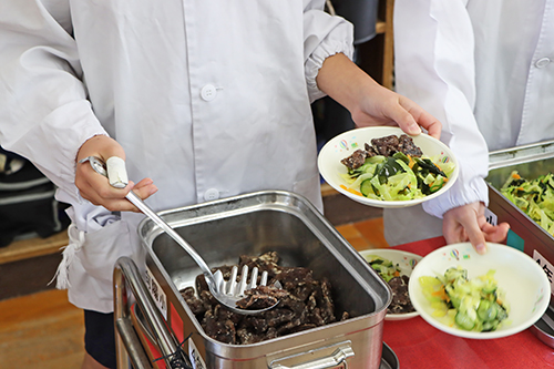 給食当番の児童が綺麗に盛り付け