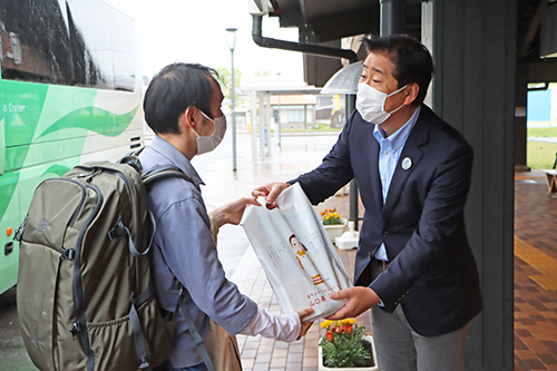 長旅を終えた乗客を労い、記念品を手渡す江原市長