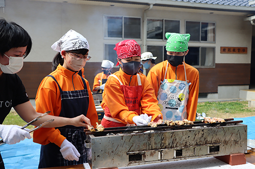 地域おこし協力隊の江島さんらの指導のもと、三隅炭で焼き鳥を焼く生徒たち
