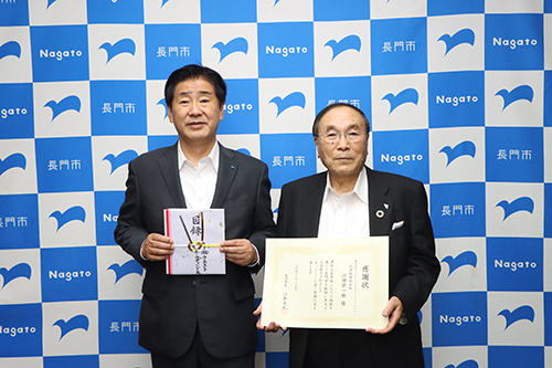 企業版ふるさと納税を行った企業に対して感謝状の贈呈があった。（左から江原市長、株式会社ウエストエネルギーの顧問 新 喜惣さん）