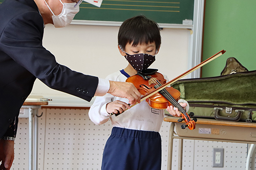 一人ひとりが楽器をもち、弓を使って音を鳴らして、バイオリンに触れた