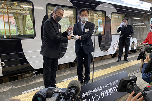 ラッピングデザインを考案したヤマシタタケシさんに江原市長から記念品を贈呈