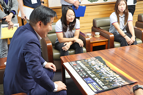江原市長は今シーズンの新しいポスターを見て笑顔