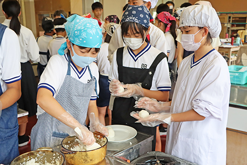 地元の塩を使っておむすびを握る
