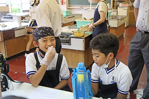 試食会で美味しそうにおむすびを食べる子どもたち