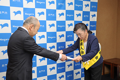 長門市交通安全母の会・会長の深本康子さんがメッセージを読み上げ、大谷副市長に手渡した