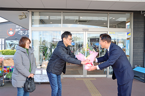 500万人目となった前田真介さん、詩穂子さんに市長から花束