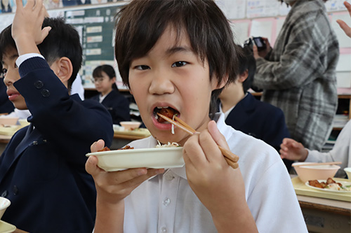 甘くて美味しいと食べる児童