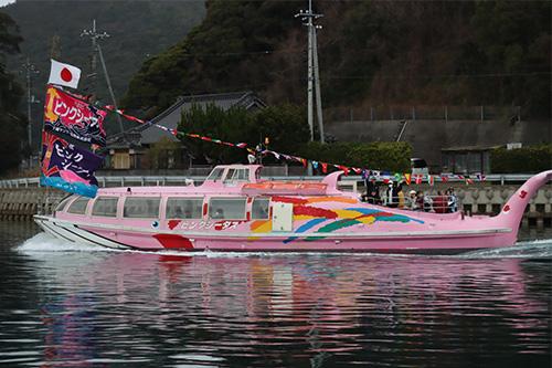船旗を掲げた観光汽船が参加者を乗せて仙崎湾を出港