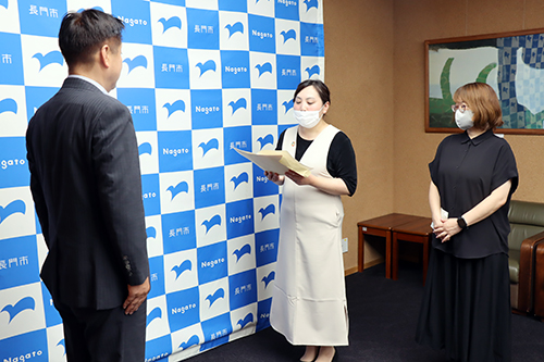 要請書を読み上げ、市長に手渡した