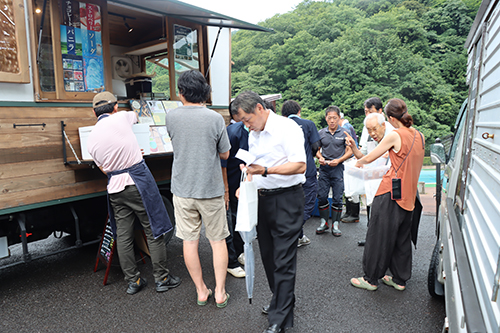 土・日曜に出店するキッチンカーの商品がお土産に手渡された