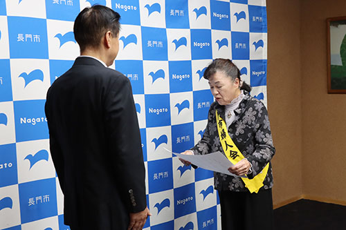長門市交通安全母の会・会長の深本康子さんがメッセージを読み上げ、大谷副市長に手渡した